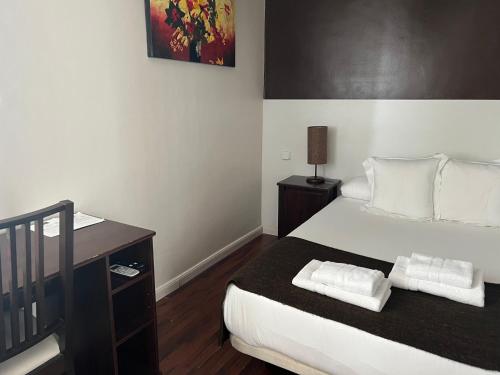 a bedroom with a bed with two towels on it at THC Gran Via Hostel in Madrid