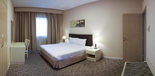 pokój hotelowy z łóżkiem i oknem w obiekcie West Zone Pearl Hotel Apartment w Dubaju