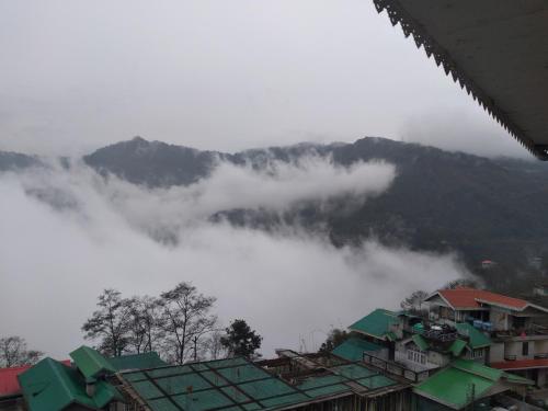 a group of houses in front of a mountain at Rufina Pinasa Residency in Gangtok