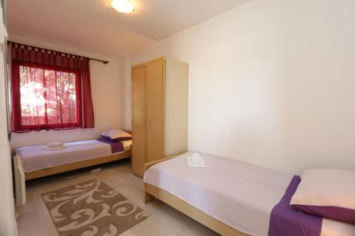 een kleine slaapkamer met 2 bedden en een raam bij Apartment Lidija in Šilo