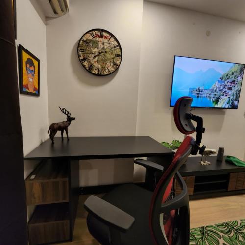 a room with a desk and a clock on the wall at The Nest Lucknow in Lucknow