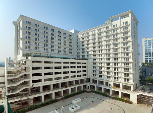 a large white building with a courtyard in front of it at The Nest Lucknow in Lucknow