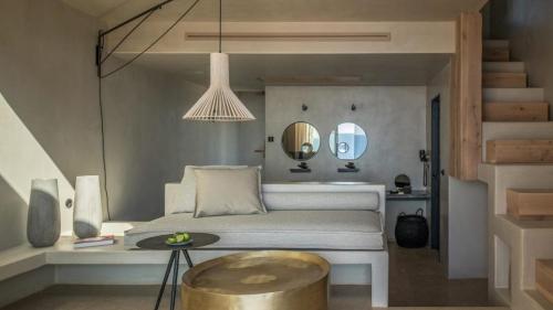 a bedroom with a bed and a table and a mirror at Acro Suites - A Wellbeing Resort in Agia Pelagia