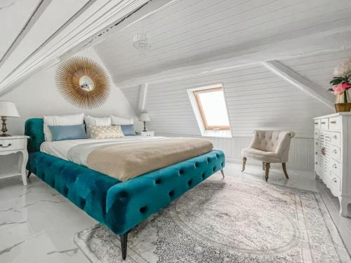 a large bedroom with a blue bed and a chair at Loft apartment in the Castle Château du Châtelard in Montreux