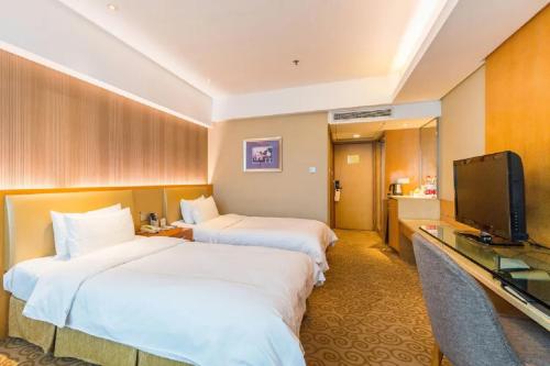 a hotel room with two beds and a television at Shu Guang International Hotel in Nanjing