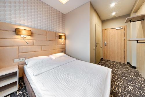 a bedroom with a large white bed in it at Citi Hotel's Łódź in Łódź