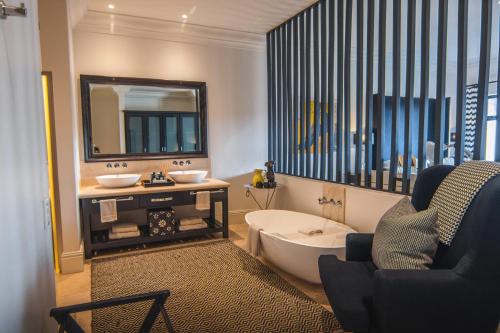 a bathroom with a tub and a sink and a mirror at Santé Wellness Retreat & Spa in Paarl