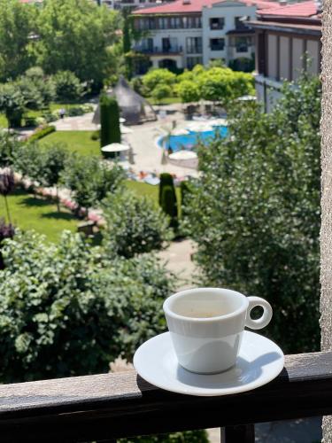 a cup of coffee sitting on top of a balcony at Green Life apartment Sozopol in Sozopol