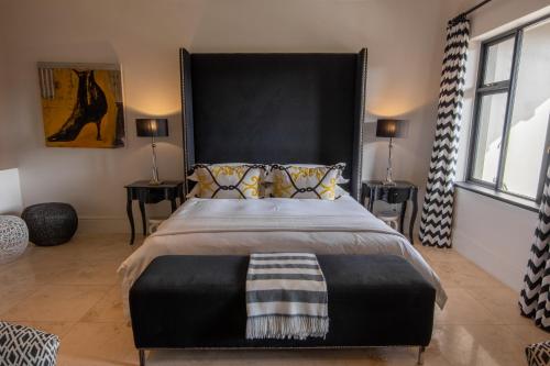 a bedroom with a large bed with a large black headboard at Santé Wellness Retreat & Spa in Paarl