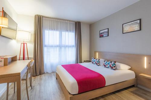 ein Hotelzimmer mit einem großen Bett und einem Schreibtisch in der Unterkunft Appart'City Classic Lyon Part Dieu Villette in Lyon