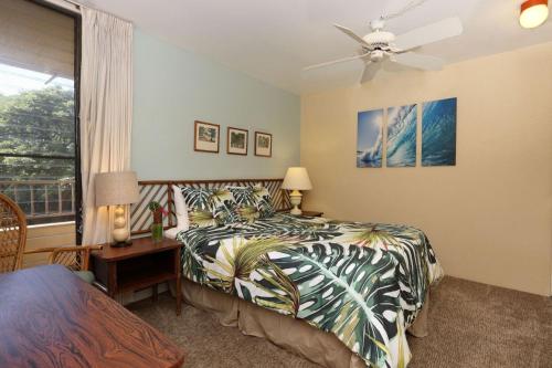 1 dormitorio con cama, escritorio y ventana en Paki Maui 313, en Kahana