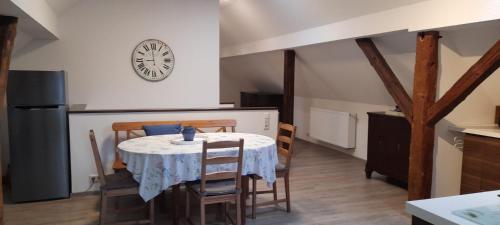 a kitchen with a table and chairs and a clock on the wall at großes Apartment mit Garten - 4 km bis zum Strand in Senftenberg