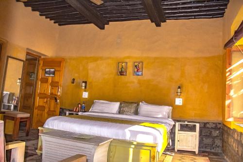 a bedroom with a large bed in a room at Prakriti Aalay - Riverside Mountain View Boutique Eco Resort in Dharamshala