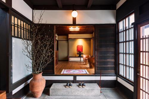 a living room with a large vase and a hallway at Rinn Shiki Juraku in Kyoto