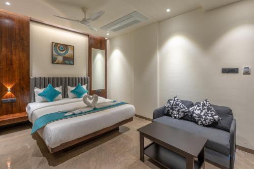 a bedroom with a bed and a couch at Hotel Devgiri in Kolhapur