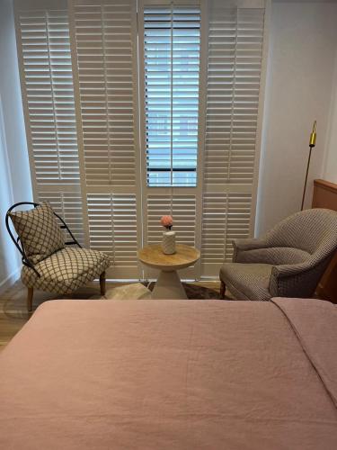 a bedroom with a bed and two chairs and a table at 夏蕾民宿 Sunny Rest in Taitung City