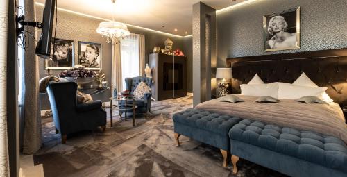 a bedroom with a blue bed and two chairs at Hotel Luise in Bad Bergzabern