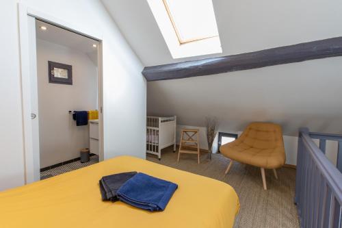 Montceau-et-Écharnant的住宿－AU COEUR DES VIGNES ENTRE BEAUNE ET DIJON，一间卧室配有黄色的床和椅子