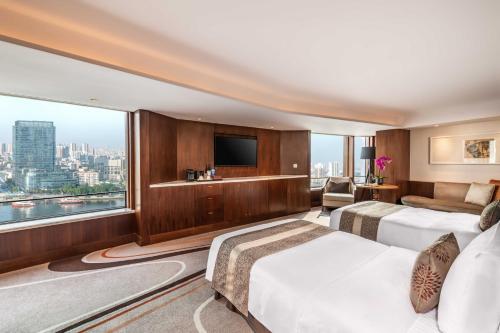 a hotel room with two beds and a large window at White Swan Hotel in Guangzhou