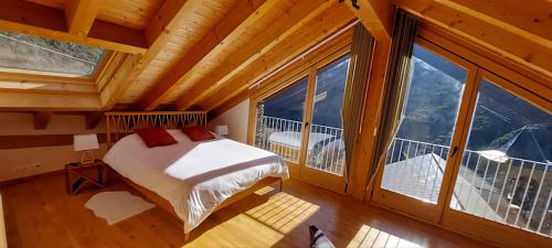 a bedroom with a bed and a large window at Antiga Rectoria, Aidí. in Aydí