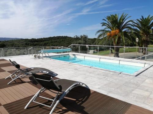 eine Terrasse mit 2 Stühlen und einem Pool in der Unterkunft Monte da Pechincha in Estremoz