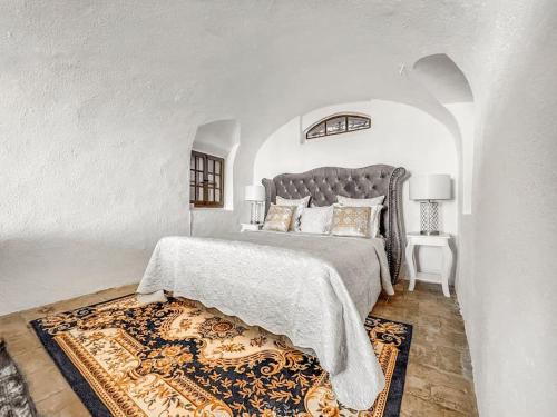 a white bedroom with a large bed and a rug at Brilliant apartment in Château du Châtelard in Montreux