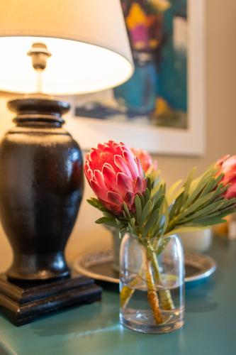 a lamp and a vase of flowers on a table at Santé Wellness Retreat & Spa in Paarl