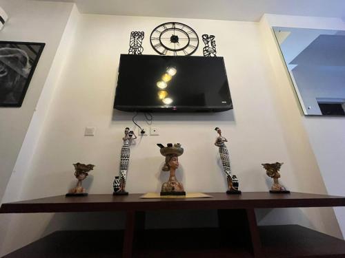 a wall with a clock and some figurines on a table at The Nest Lucknow in Lucknow