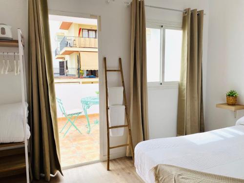 La Bartola Guesthouse في مدينة إيبيزا: غرفة نوم بسرير وسلم بجانب نافذة