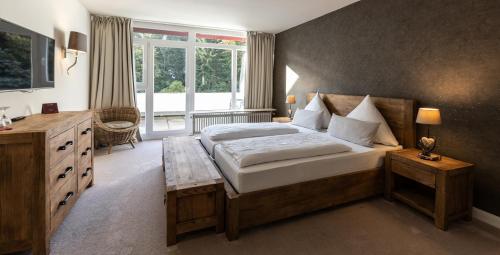 a bedroom with a large bed and a window at Hotel Luisenpark in Bad Bergzabern