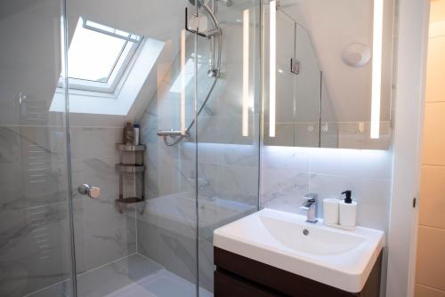 a bathroom with a sink and a glass shower at Walnut Flats-F4, 2-Bedroom with Ensuite - Parking, Netflix, WIFI - Close to Oxford, Bicester & Blenheim Palace in Kidlington