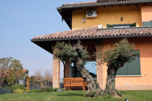 uma casa com um banco de madeira no quintal da frente em B&B Belvedere em Lurago Marinone