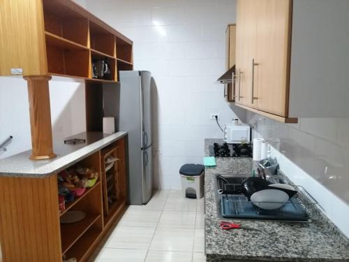 a kitchen with a refrigerator and a counter top at Habitación matrimonial privada con areas compartidas in Las Lagunas
