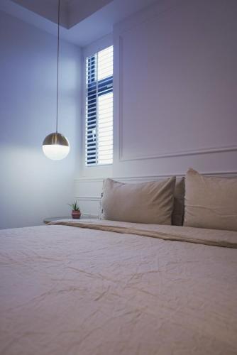 a large bed in a white room with a window at 夏蕾民宿 Sunny Rest in Taitung City