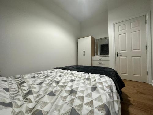een slaapkamer met een bed en een witte deur bij Bee Accommodations in Leicester