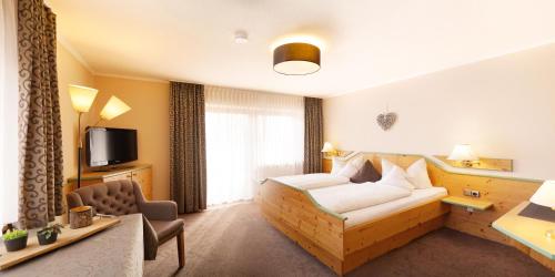 a hotel room with a bed and a desk at Landhaus Riedl in Bad Füssing