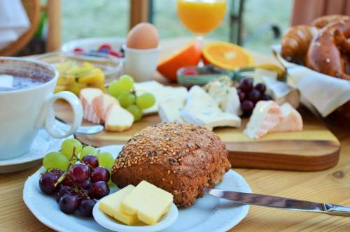 a table with a plate of food with cheese and fruit at Landhaus Riedl in Bad Füssing