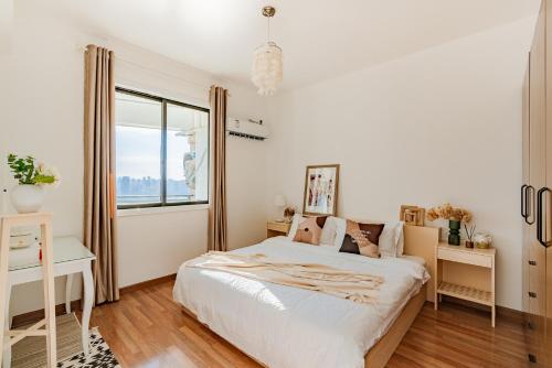a white bedroom with a bed and a window at King'sLandind BnB in Chongqing