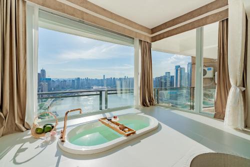 un bagno con vasca di fronte a una grande finestra di King'sLandind BnB a Chongqing