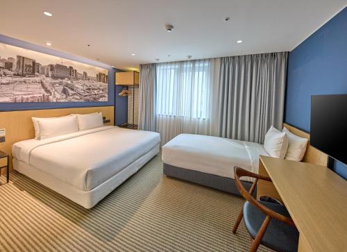 首爾的住宿－Travelodge Myeongdong City Hall，酒店客房配有两张床和一张书桌