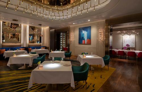 a restaurant with white tables and green chairs at Galaxy Macau in Macau