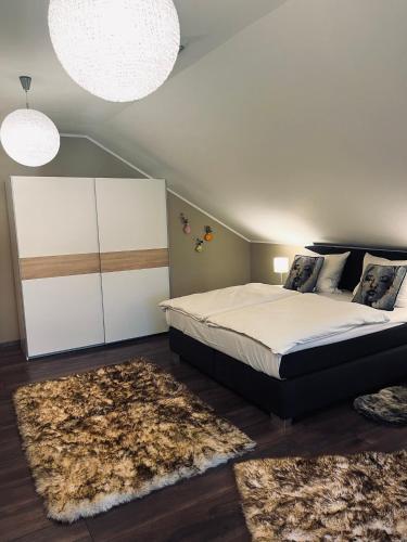 a bedroom with a large bed and two rugs at gemütliche Wohnung alpenländisch in Lüdenscheid