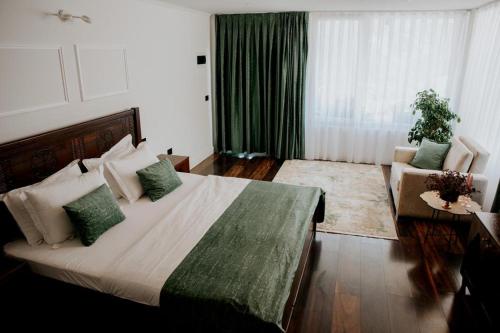 a bedroom with a large bed with green pillows at Hotel Thethi in Theth