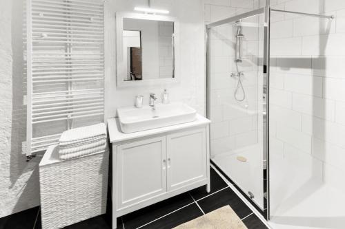 y baño blanco con lavabo y ducha. en Medieval apartment Juliette, en Montreux