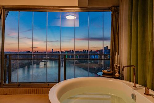a bath tub in a bathroom with a large window at King'sLandind BnB in Chongqing