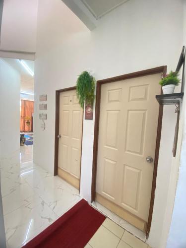 a hallway with two doors and a potted plant at LH Homestay Bandar Utama Gua Musang in Gua Musang