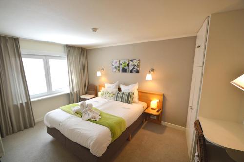 a bedroom with a bed with a teddy bear on it at Hotel Ambrosia in Ypres