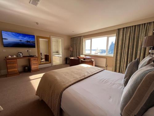 a hotel room with a large bed and a television at St Kyrans Guest House in Virginia