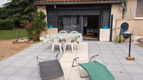 a table and chairs and a television on a patio at Studio au bord de l'étang in Laives