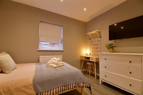 a bedroom with a bed with a dresser and a desk at 'Bellerose' at stayBOOM in Scotforth